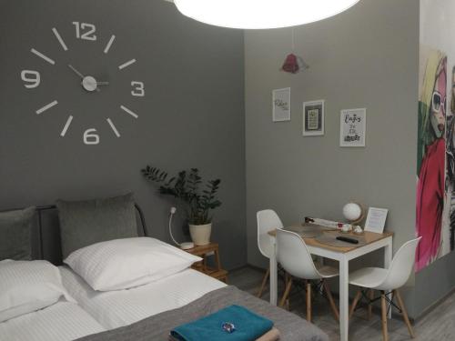 a bedroom with a bed and a clock on the wall at Apartament Easy Stay Center in Wrocław