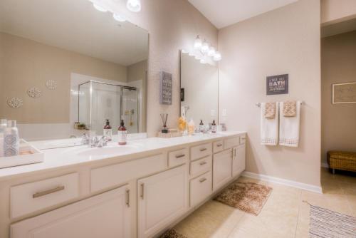 a bathroom with two sinks and a large mirror at Vista Cay Resort by Casiola in Orlando