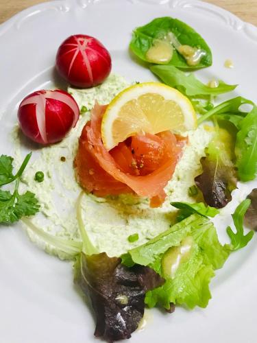 a white plate of food with lettuce and tomatoes at Appartement T3 Aux Deux Cigognes Gries in Gries