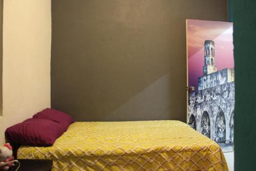 Casa en el centro de veracruz في فيراكروز: غرفة نوم بسرير وصورة برج