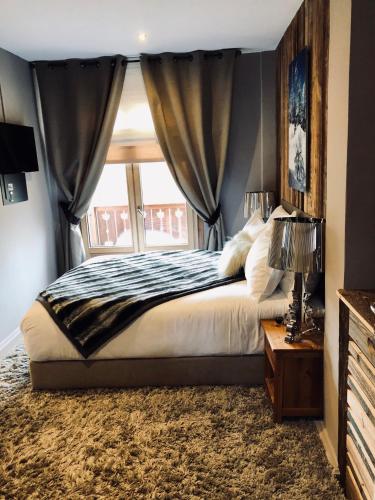 a bedroom with a large bed with a window at Coeur des Neiges in Saint-Gervais-les-Bains