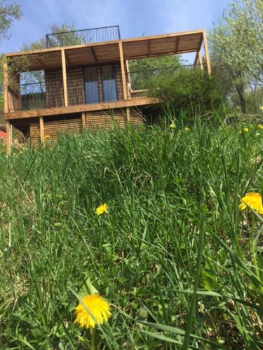 a house sitting on top of a hill with flowers at Loft "Home, Sauna & Pool" in Osenbach