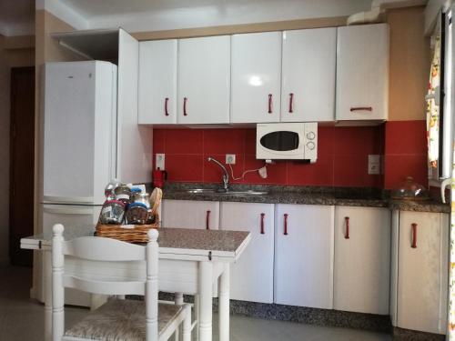 a kitchen with white cabinets and a white refrigerator at Apartamento centro in Antequera