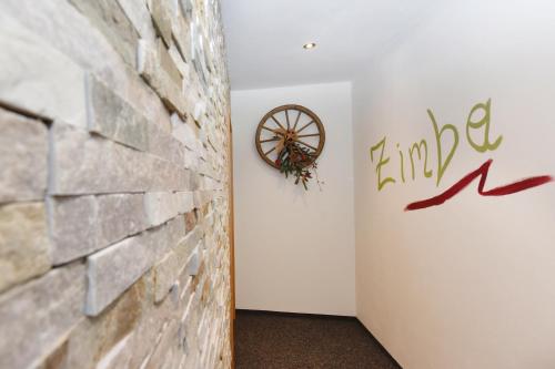 a room with a brick wall and a clock on a wall at Salzgeber Appartements in Sankt Gallenkirch