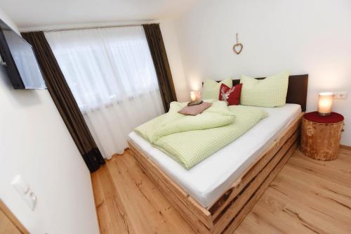 a bed in a room with two candles on it at Salzgeber Appartements in Sankt Gallenkirch