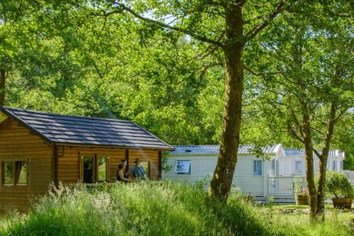 two people standing outside of a log cabin at Heart of Glencoe Holidays in Glencoe