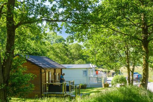 a man standing on the porch of a tiny house at Heart of Glencoe Holidays in Glencoe