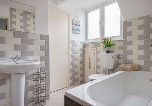 a bathroom with a tub and a sink and a toilet at Corner Cottage Mevagissey in Mevagissey