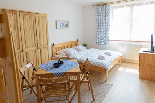 a bedroom with a bed and a table and chairs at Žltý Dom in Terchová