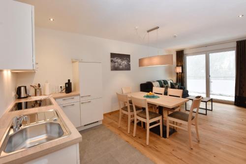 a kitchen and living room with a table and chairs at Salzgeber Appartements in Sankt Gallenkirch