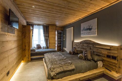 sypialnia z dużym łóżkiem i drewnianą ścianą w obiekcie Alpine Rooms Guesthouse w mieście Breuil-Cervinia