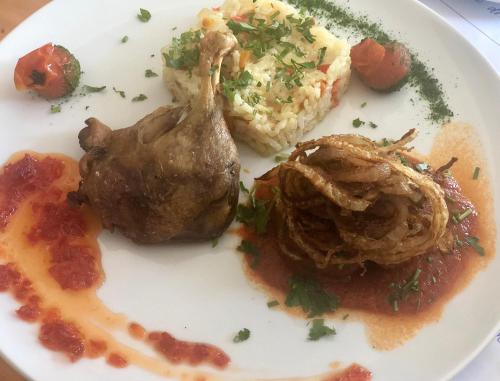 a plate of food with meat and mashed potatoes and gravy at Vila Teleconstructia in Slănic-Moldova