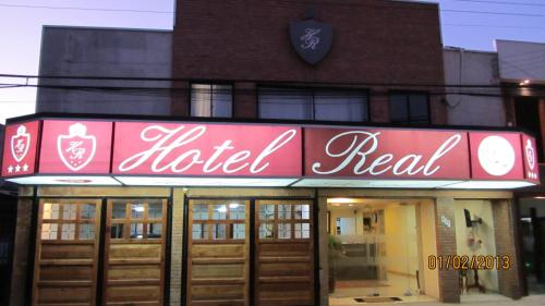 a red hotel sign in front of a building at Hotel Real in Linares