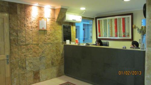 a restaurant with a counter with two people sitting at a waiting room at Hotel Real in Linares