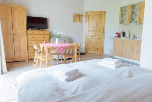 a bedroom with a table and a bed with towels on it at Žltý Dom in Terchová