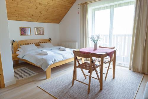 1 dormitorio con cama, mesa, mesa y silla en Žltý Dom, en Terchová