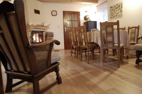 a living room with a table and chairs and a fireplace at Dom nad potokiem in Krzyżanów