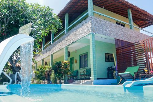 uma casa com piscina e uma fonte de água em Pousada Estrela do Oriente em Taíba