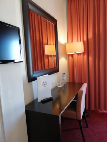 a hotel room with a desk and a television at Hotel Monaco in Faro