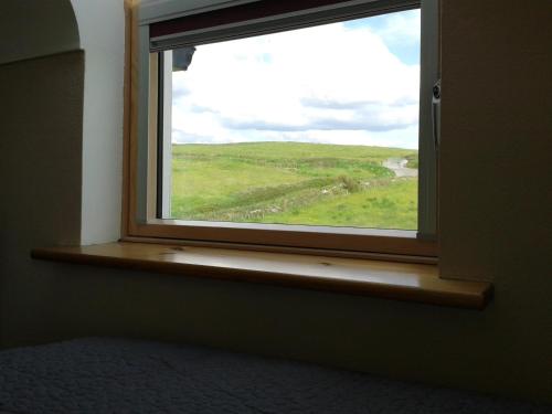a window with a view of a green field at Blackberry Lodge Accommodation in Doolin