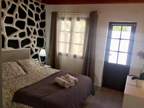 a bedroom with a bed with two rolled up towels on it at Casa Gloria in Tías