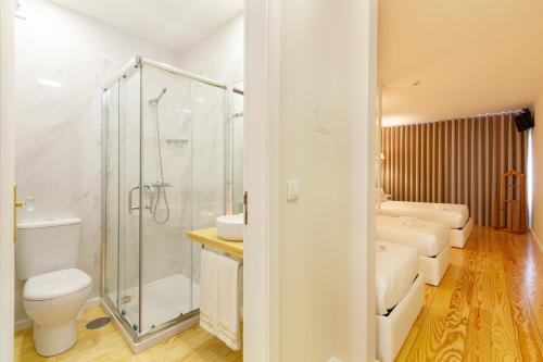 a bathroom with a shower and a toilet and a sink at Berço de Mordomias in Braga