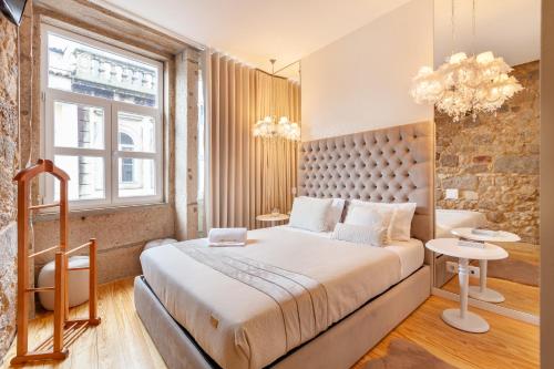a bedroom with a large bed and a brick wall at Berço de Mordomias in Braga