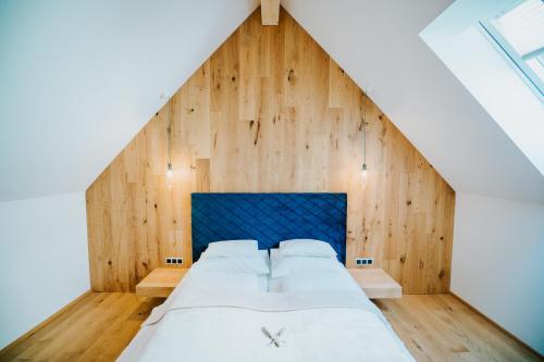 a large bed in a room with a wooden wall at Der Kleine Bär in Hermagor