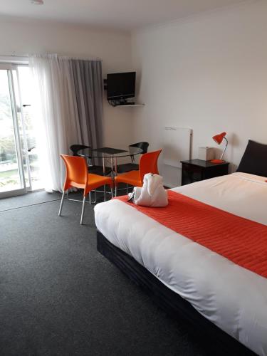 een hotelkamer met een bed en een tafel en stoelen bij Mokau Motels in Mokau