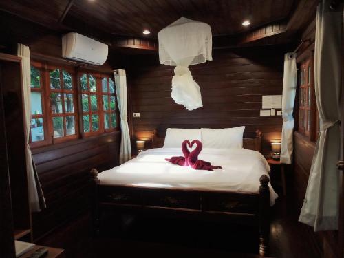 una cinta rosa sentada en una cama en una habitación en Cozy Garden Resort, en Ao Nang Beach