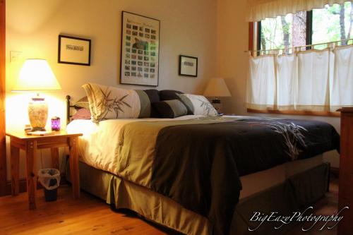 The Meadow Cabin في Folsom: غرفة نوم بسرير وطاولة مع مصباح