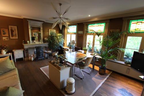 a living room with a table and some plants at B&B De Lachende Engel in Mechelen