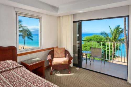 a bedroom with a bed and a view of the ocean at Ka'anapali Beach Hotel in Lahaina