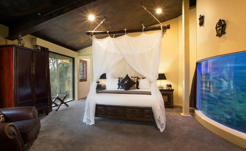 a bedroom with a bed with a mosquito net at Jamala Wildlife Lodge in Canberra