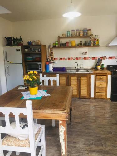 eine Küche mit Holztisch und Kühlschrank in der Unterkunft Benito Soria 137 in Santa Rosa de Calamuchita