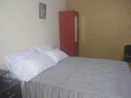 a bedroom with a large bed with a red cabinet at Hospedaje Golden Inn in Camaná