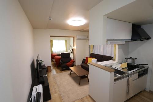 a kitchen and a living room with a couch at Reussir Yamahanaminami 101 in Sapporo