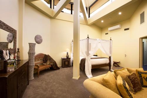 a bedroom with a bed and a couch in a room at Jamala Wildlife Lodge in Canberra