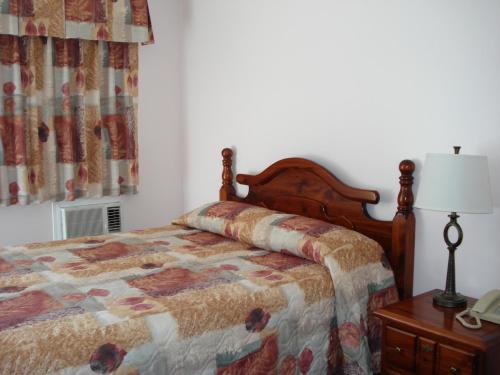 a bedroom with a bed and a table with a lamp at Mountain Springs Motel & RV Park in Barrière