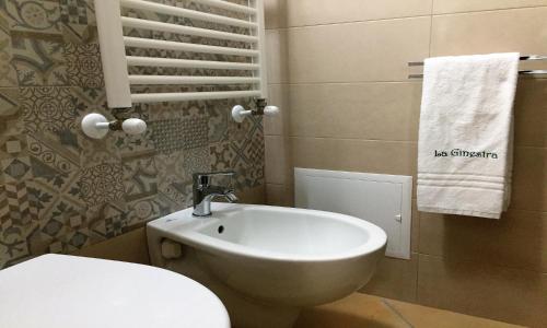 a bathroom with a white toilet and a sink at La Ginestra Affittacamere in Ginosa