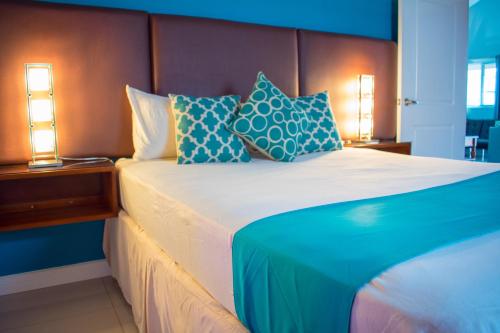 a bedroom with a bed with blue and white pillows at Casa Victoria Golf Retreat in Caymanas