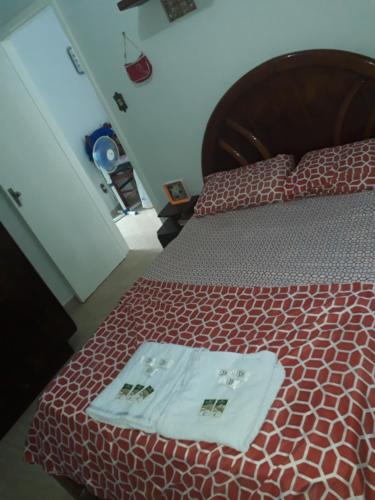 a bedroom with a bed with two towels on it at Apto Temporada na Ilha de Paquetá in Paquetá