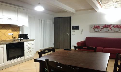 a living room with a table and a red couch at La Ginestra Affittacamere in Ginosa