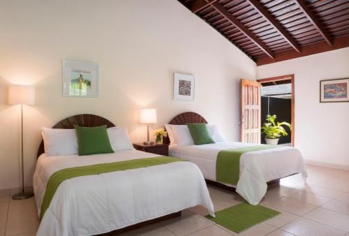 Un dormitorio con dos camas y una ventana. en White Sands Negril, en Negril