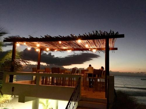 a restaurant on the beach with birds on a pergola at White Sands Negril in Negril