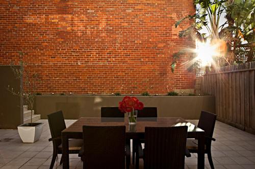 a dining room with a table and chairs and a brick wall at Brighton Bay Apartments in Melbourne