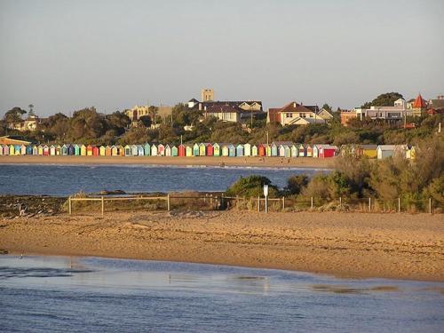 a beach with houses in the background and a city at Brighton Bay Apartments in Melbourne