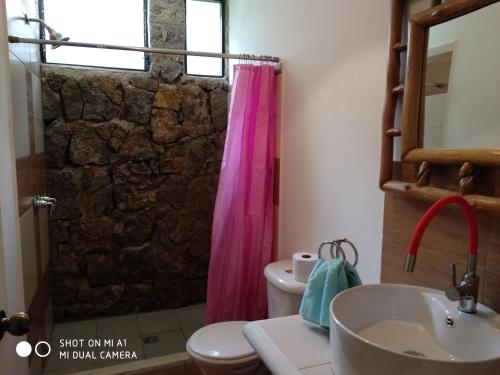 a bathroom with a shower with a pink shower curtain at Paraíso San José in Santa Cruz Verapaz