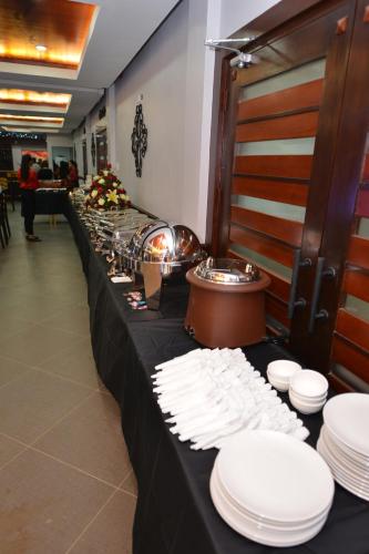 a long black table with white plates on it at Hotel Gabriella in Tagbilaran City