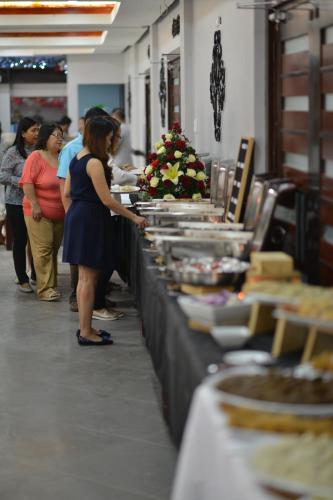 a woman standing in front of a buffet line at Hotel Gabriella in Tagbilaran City